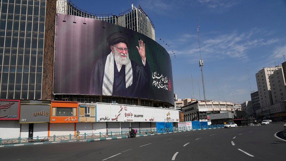 A billboard showing a portrait of Ayatollah Ali Khamenei over an empty square in Tehran