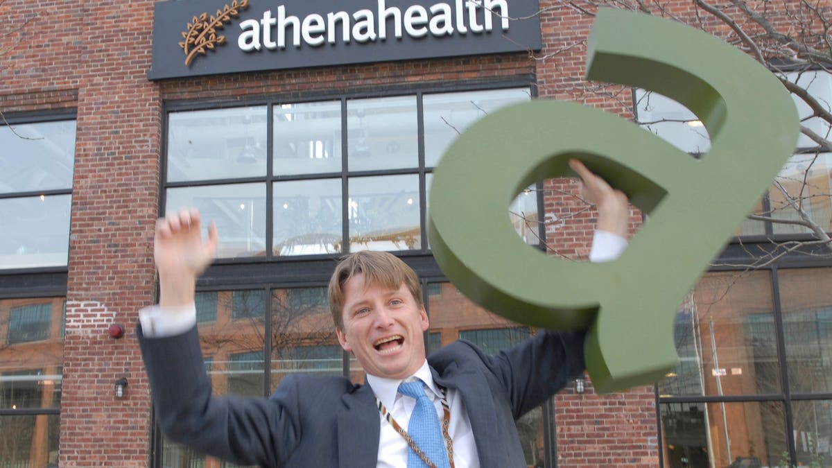 Jonathan J. Bush Jr. smiling and gesturing inside athenahealth office in Watertown Massachusetts