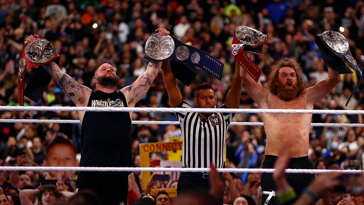 Kevin Owens and Sami Zayn celebrating after winning WWE tag team championship at SoFi Stadium
