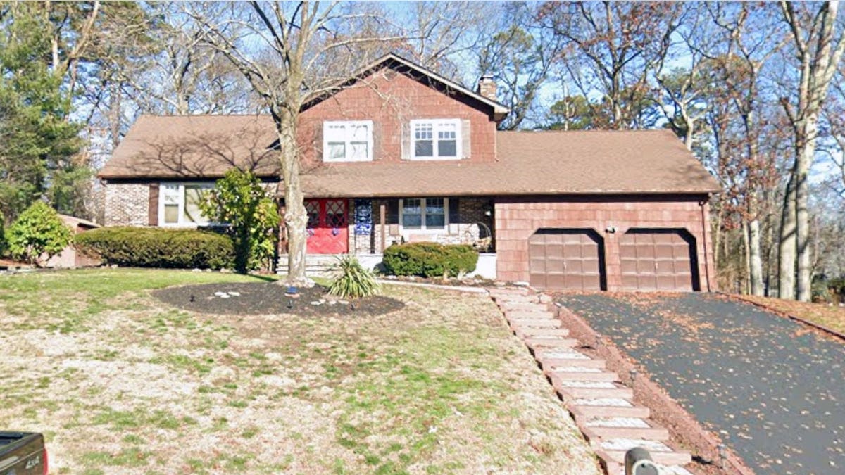 Exterior view of a two-story suburban home with a driveway and attached two-car garage in Ocean Township, New Jersey.