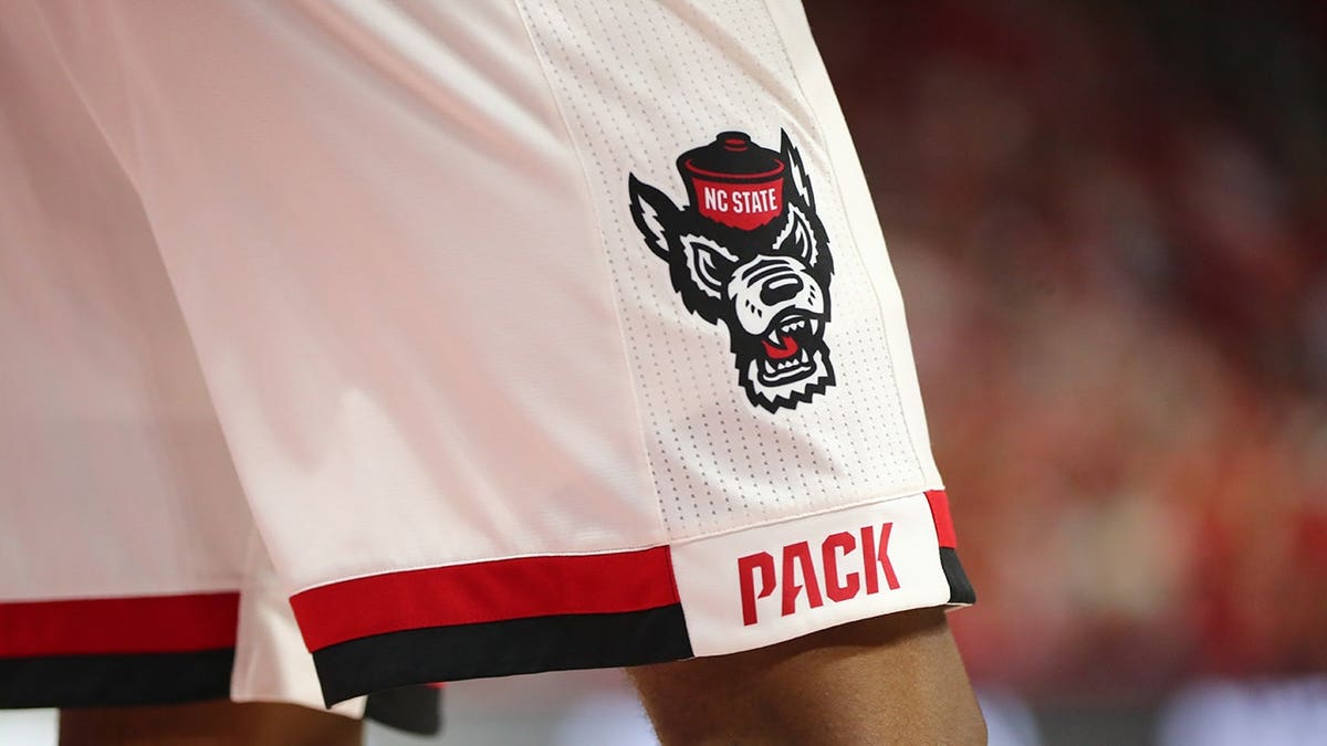 North Carolina State Wolfpack logo displayed on a basketball court floor.