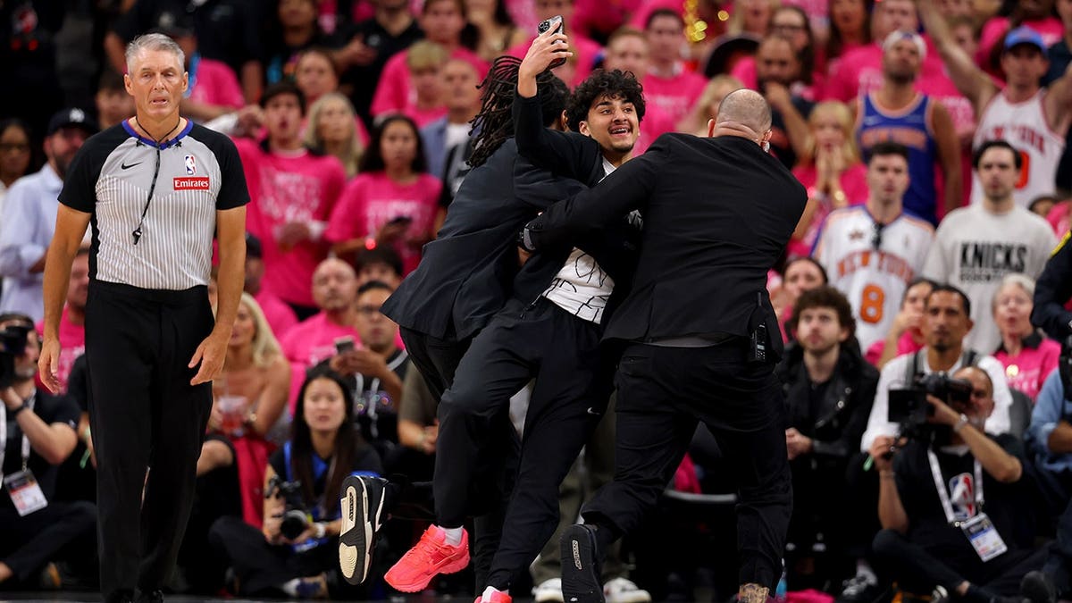 A fan named Gregory Shamus detained by security on basketball court during NBA Finals game