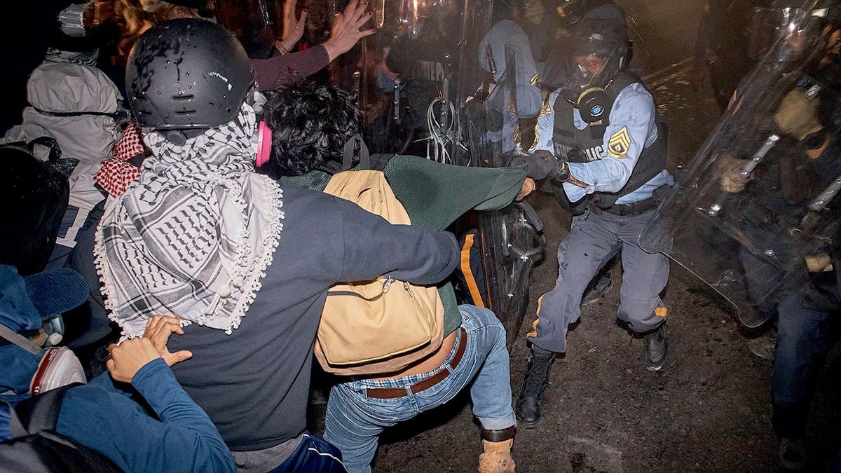 State police officers arrest a person outside Delaney Hall detention center during a protest in Newark
