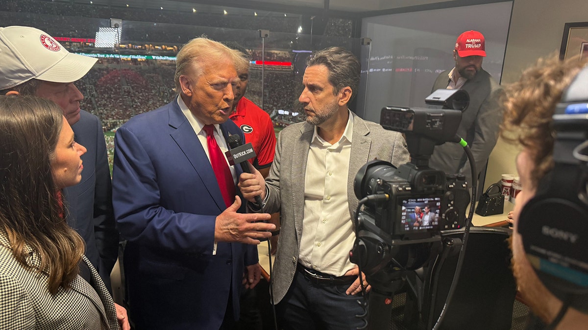 Clay Travis interviewing former President Trump during a football game halftime in Tuscaloosa Alabama