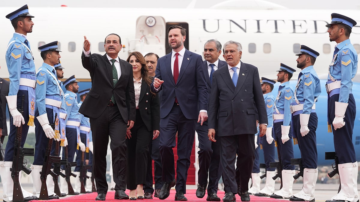 JD Vance walking alongside Asim Munir and Mohammad Ishaq Dar in a formal setting.