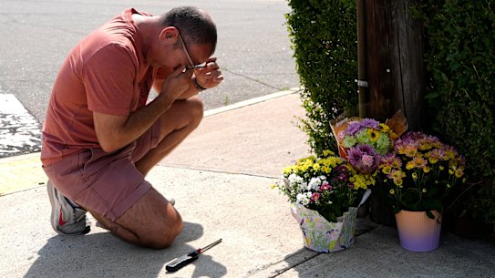Misael Valdez kneeling at an intersection where the fatal shooting occurred.