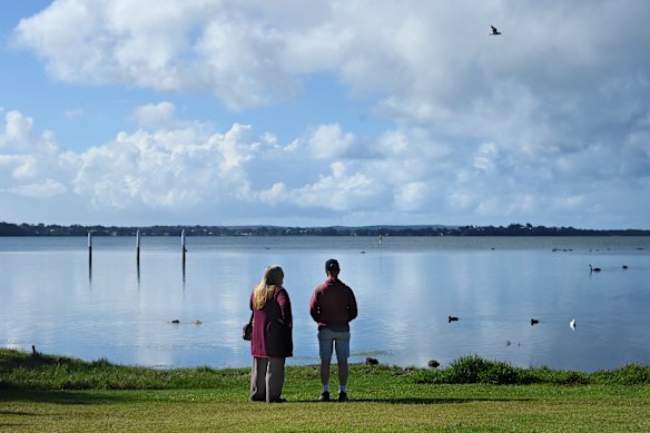 A woman and man look out over Budgewoi Lake from Wallarah Point Peace Park in Gorokan.