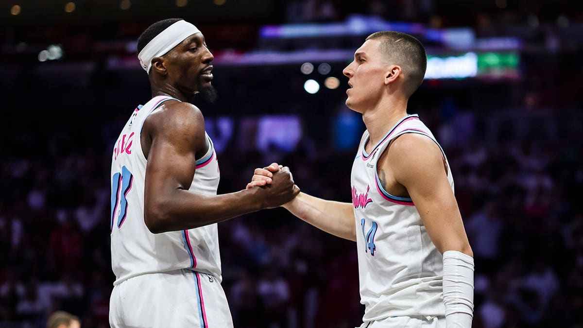 Bam Adebayo and Tyler Herro shaking hands during a game.