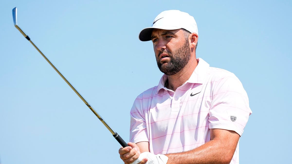 Scottie Scheffler stands on the fifth tee at a golf course.