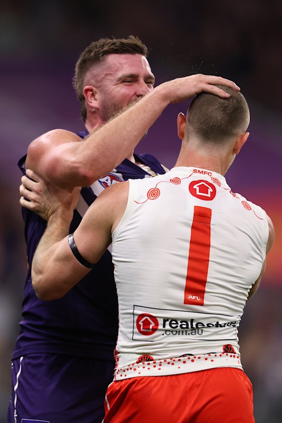 Luke Ryan of the Dockers rubs the head of Chad Warner of the Swans to give away a free kick.