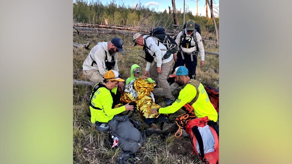 Rescue team hikes through steep terrain to reach hiker Guinn.