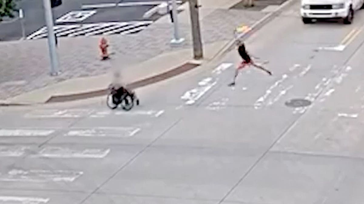 A suspect seen about to throw a Molotov cocktail at another man in a wheelchair