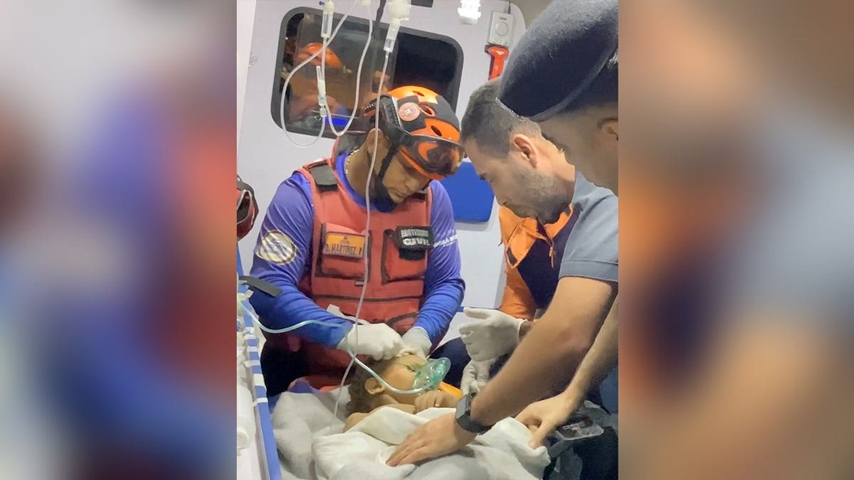 A child receives emergency medical attention after being rescued by a Jordanian team from under rubble following earthquakes in Venezuela