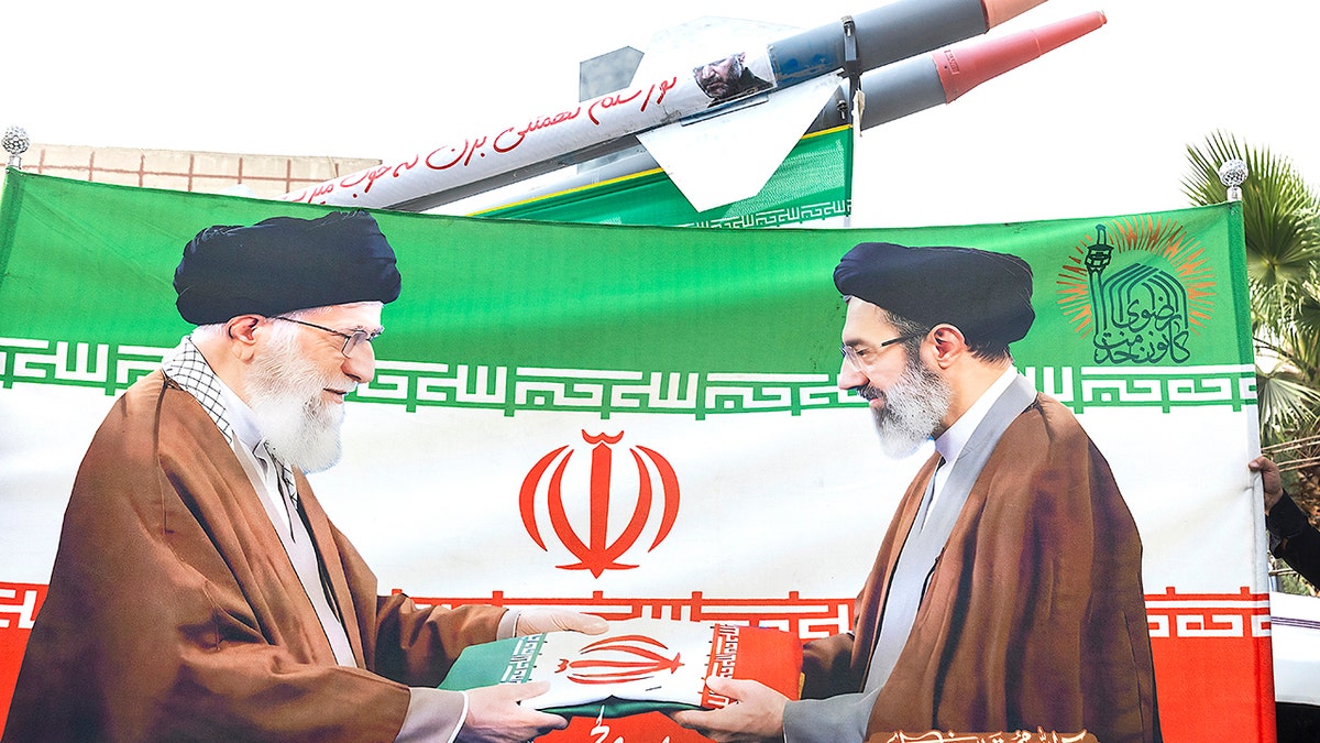 An image of Iran's late Supreme Leader Ali Khamenei (L) and new Supreme Leader Mojtaba Khamenei with replicas of missiles in the background during a gathering to commemorate the death of Imam Reza on August 12, 2026 in Tehran, Iran. (Photo by Contributor/Getty Images)