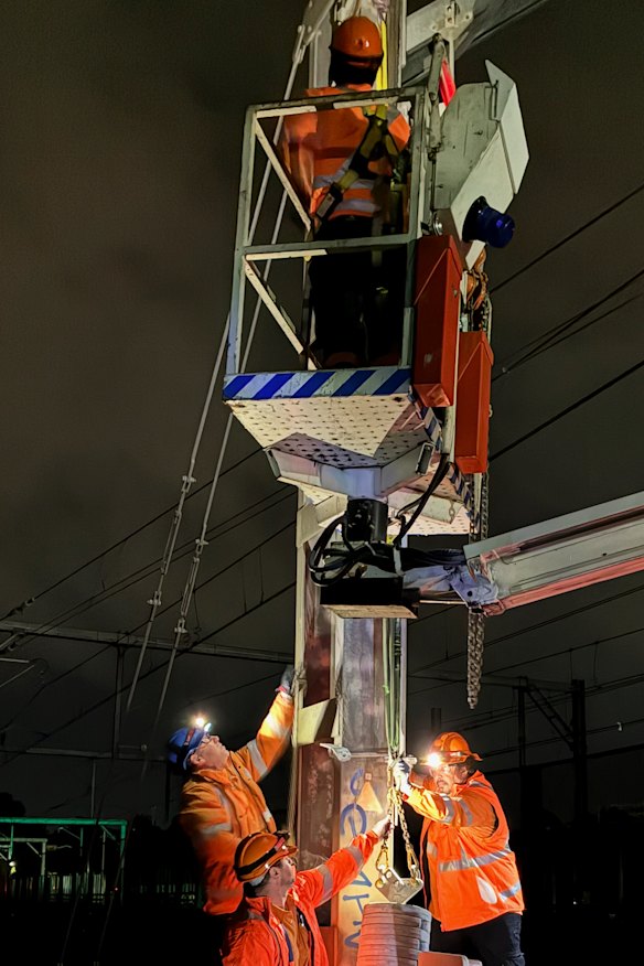 Crews work on repairing the counterweight which failed on the T1 line south of Chatswood.