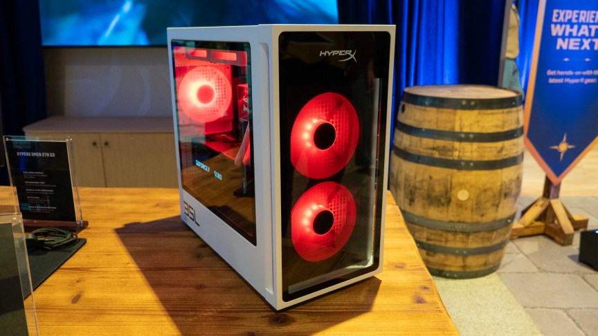 HyperX Omen 35L gaming desktop computer with AMD processor and a white case sits on a wood-grain desk.
