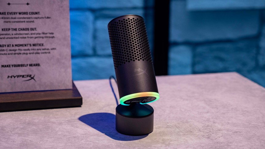The HyperX SoloCast 2 Pro microphone sits tilted upwards on a table.