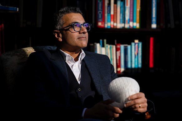 Professor Anand Deva shows the 3D-printed breast scaffold in a medical library in Sydney.