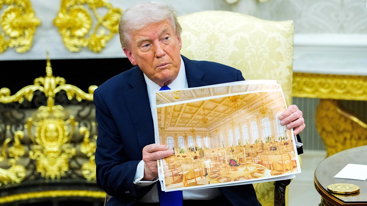 President Donald Trump displays architectural design boards for a proposed White House ballroom during a public appearance.