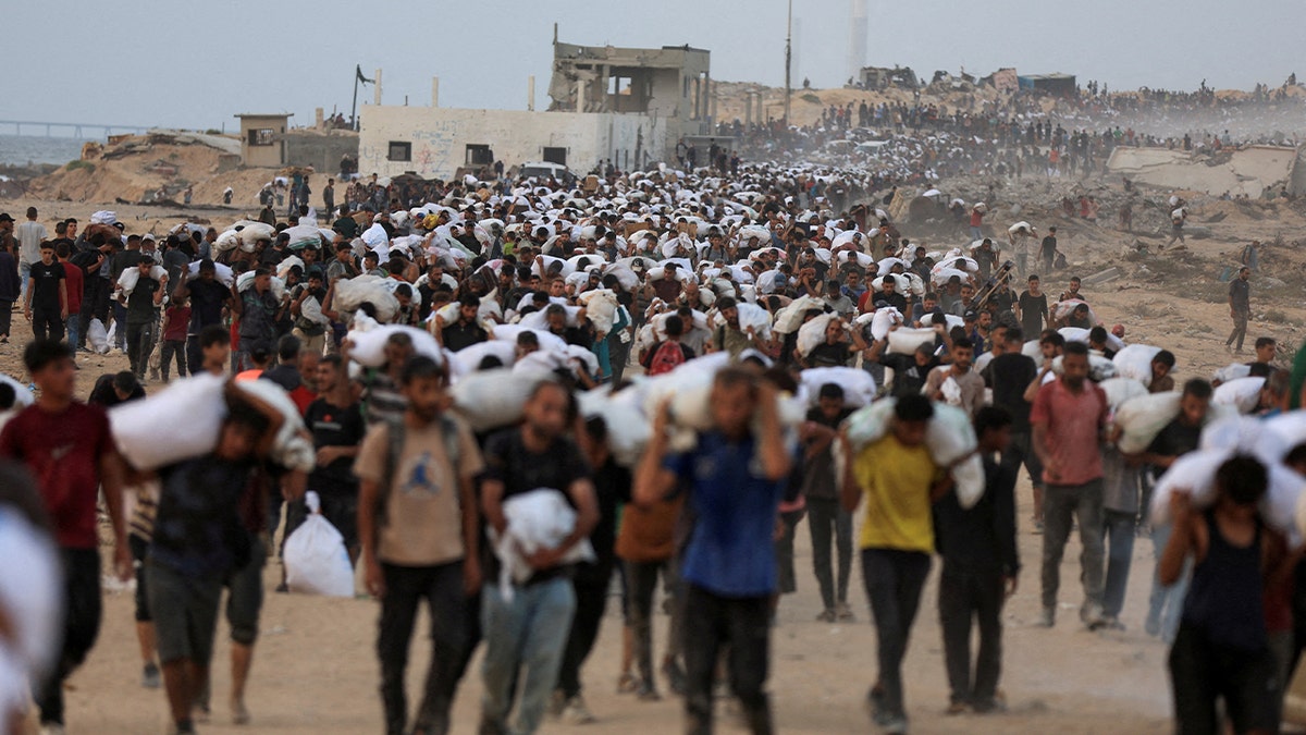 Palestinians carry aid supplies, that entered Gaza on trucks through Israel, in Beit Lahia, in the northern Gaza Strip July 29, 2025.