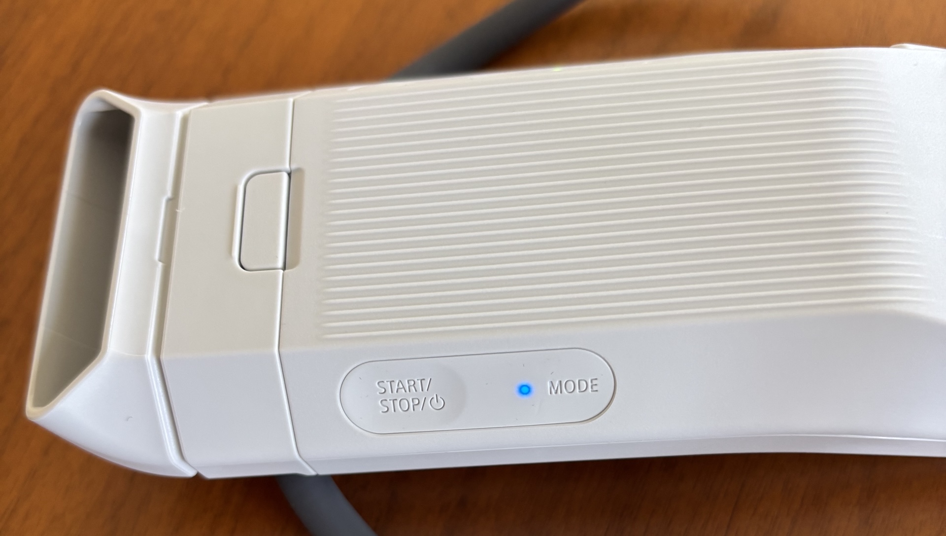 A close-up image of the Sony Reon Pocket Pro Plus mode button with a blue LED light.