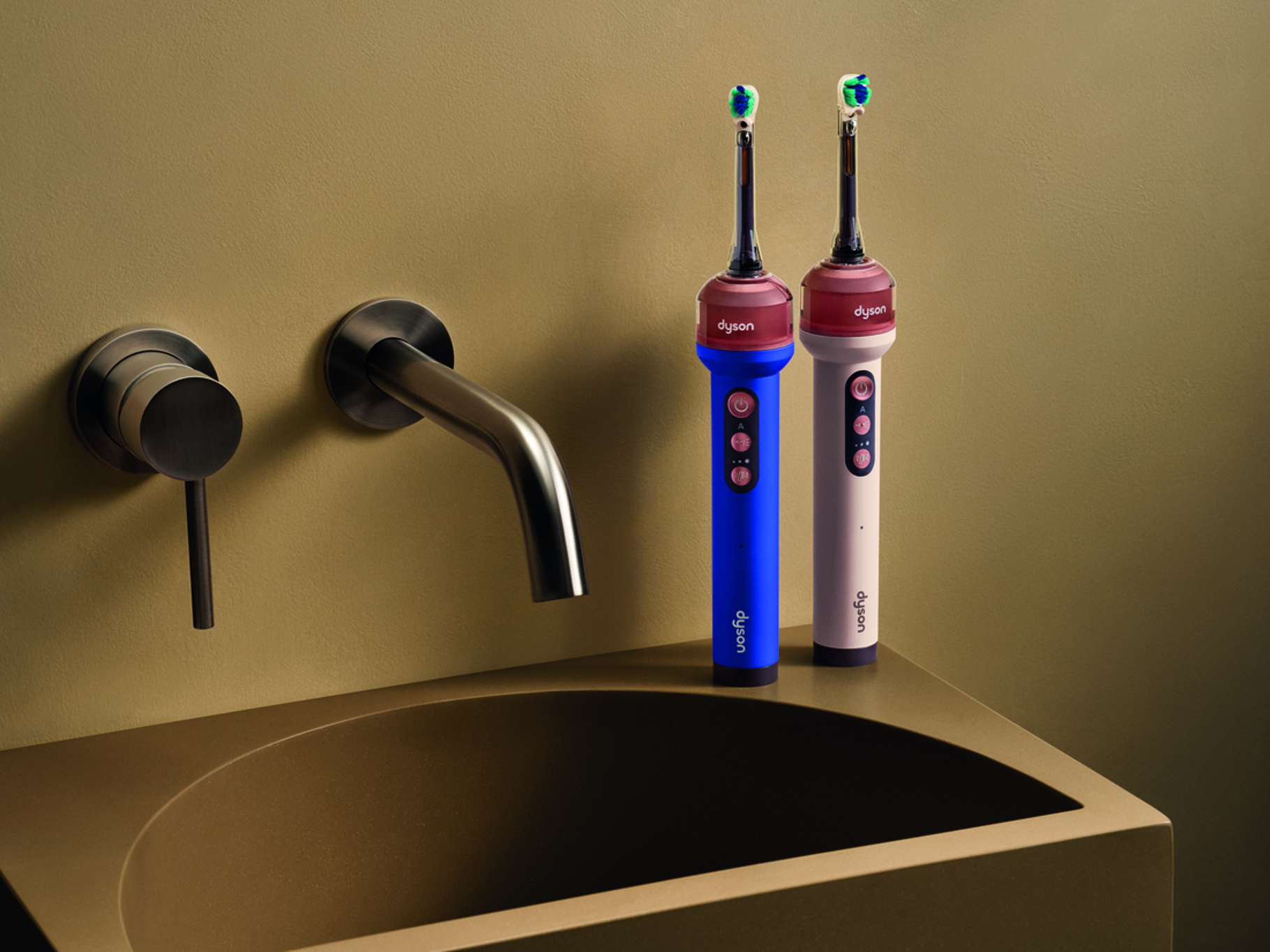 The blue and pink Dyson CameraJet toothbrushes on a bronze bathroom countertop.