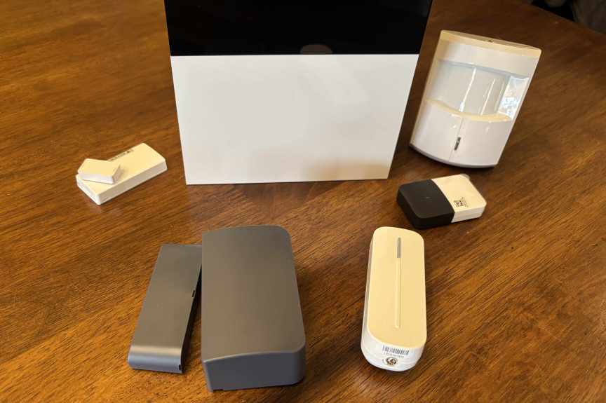 Abode sensors on a wood table.