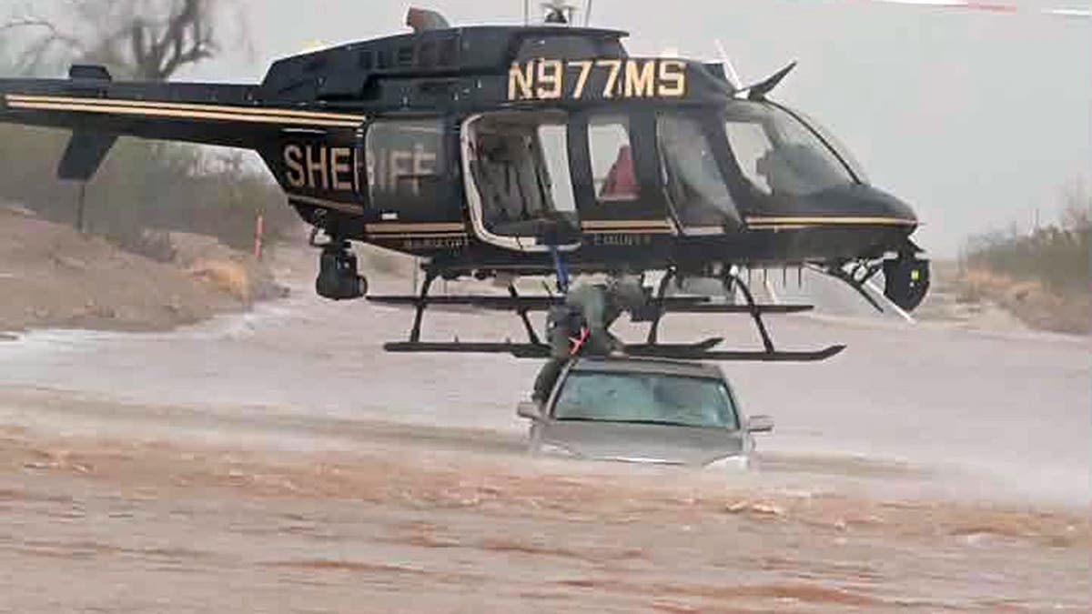 Helicopter flies close to stranded vehicle to conduct water rescue