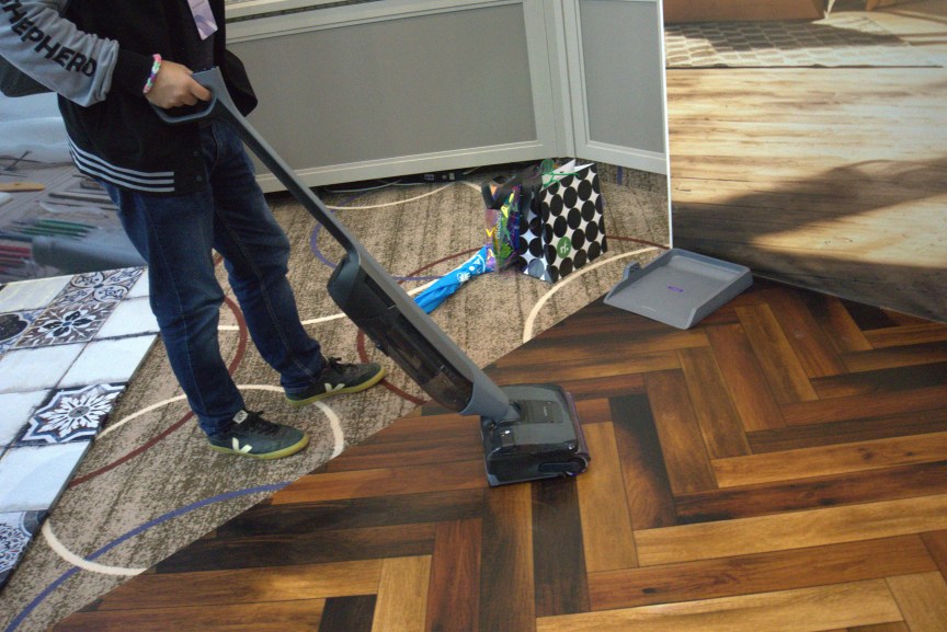 The writer demos the Narwal cube on hard floor.