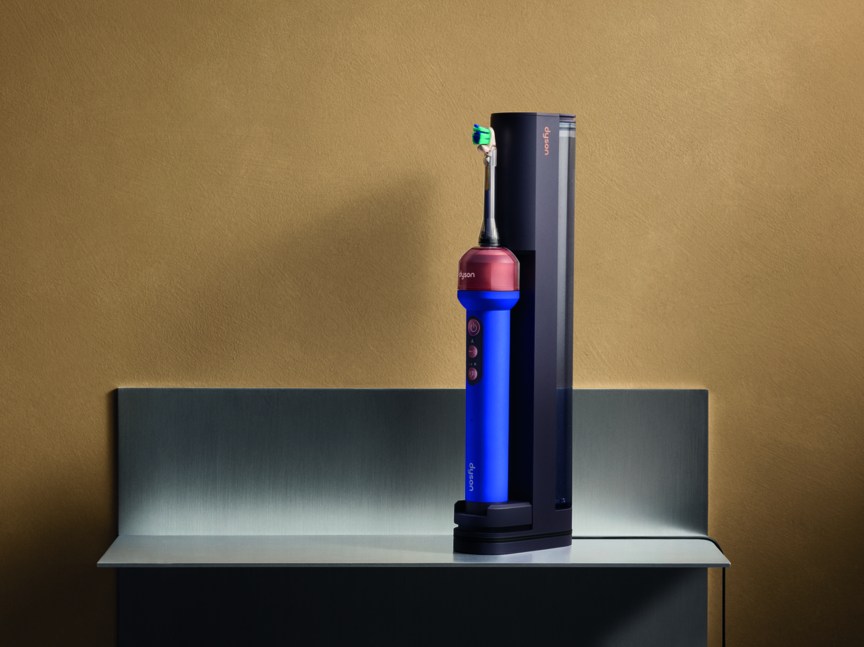 The blue Dyson CameraJet toothbrush on a charging station. 