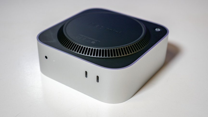 the bottom of a mac mini. it's sitting upside down on a glossy white table.