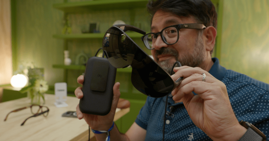 Scott Stein holding up Meta VR Glasses and their processor battery puck