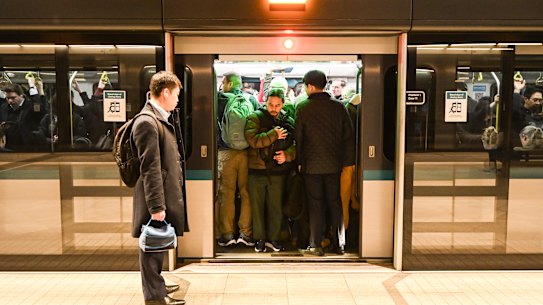 A commuter is left waiting for the next train at Crows Nest station because he cannot get on a packed service.