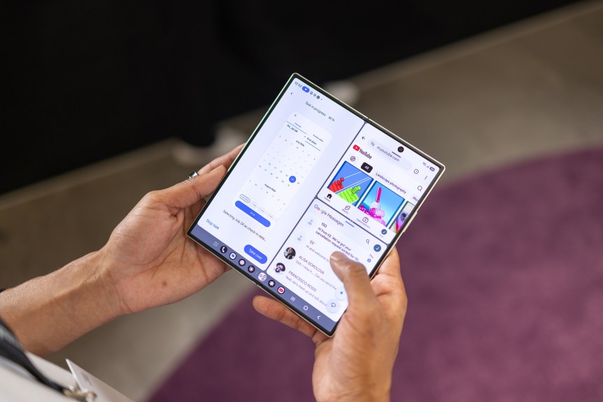A foldable phone unfolded to show its large screen, with two apps running separately on the right and left halves.