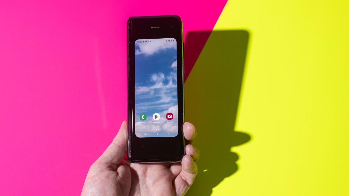 A hand holding a Samsung foldable phone