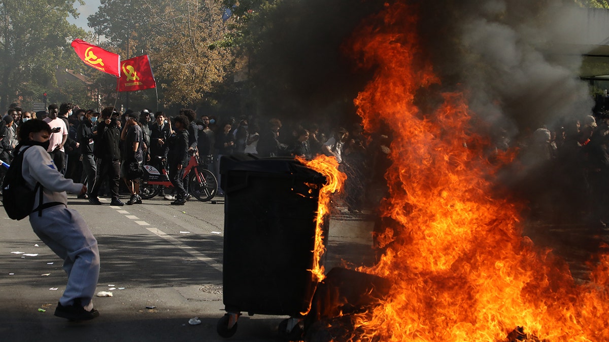 Protesters near flaming trash bin in France