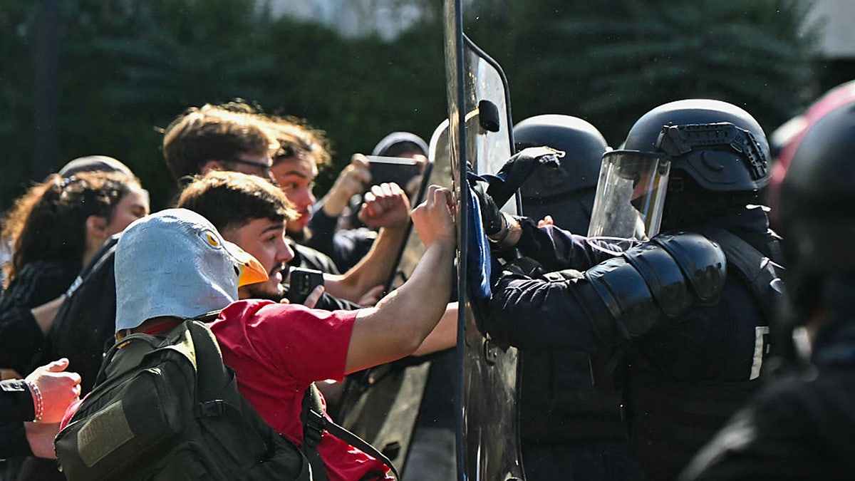 TOPSHOT - Anti-riot police officers face protesting students carrying out blockading action outside the secondary school Le Corbusier, in Aubervilliers, northern Paris on October 1, 2026. Since late September, students have staged protests outside schools over grievances ranging from timetables, class sizes and a shortage of teachers to overheated classrooms during this year's heatwaves. The protests started in the Ile-de-France region around Paris but have now spread to other cities nationwide.