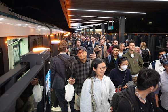 Passengers alight after riding the first southbound M1 train service which arrived at Bankstown before dawn.