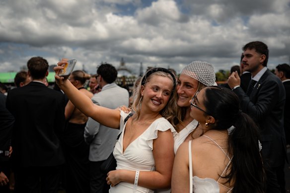 Ebony Rowe, Sophie Graham-Jones and Elisa Petrelli taking a selfie in the general admission area at Flemington Racecourse on Derby Day. 