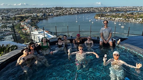 Friends gather in a rooftop pool in an apartment complex in Newstead, Brisbane.