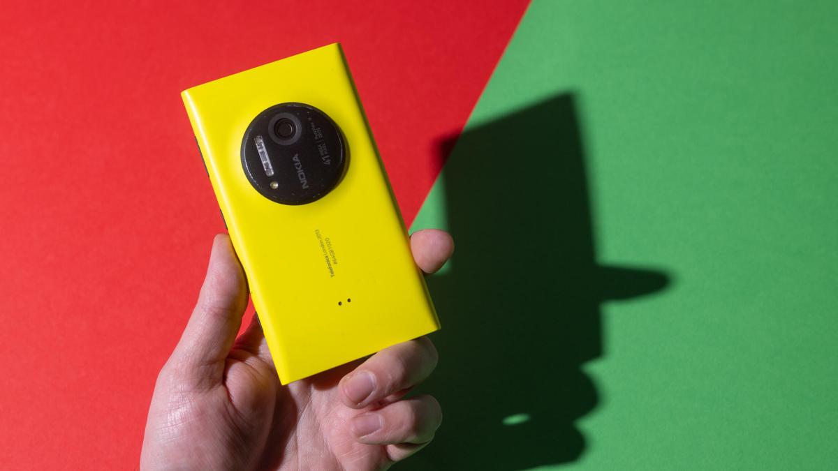 A hand holding a yellow Nokia phone