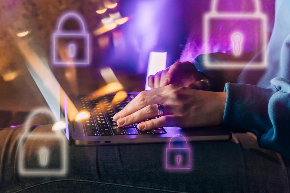 A person's hands on their keyboard with images of locks flying around the screen.