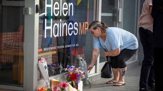 A woman laying flowers outside Helen Haines’ electorate office in Wangaratta.