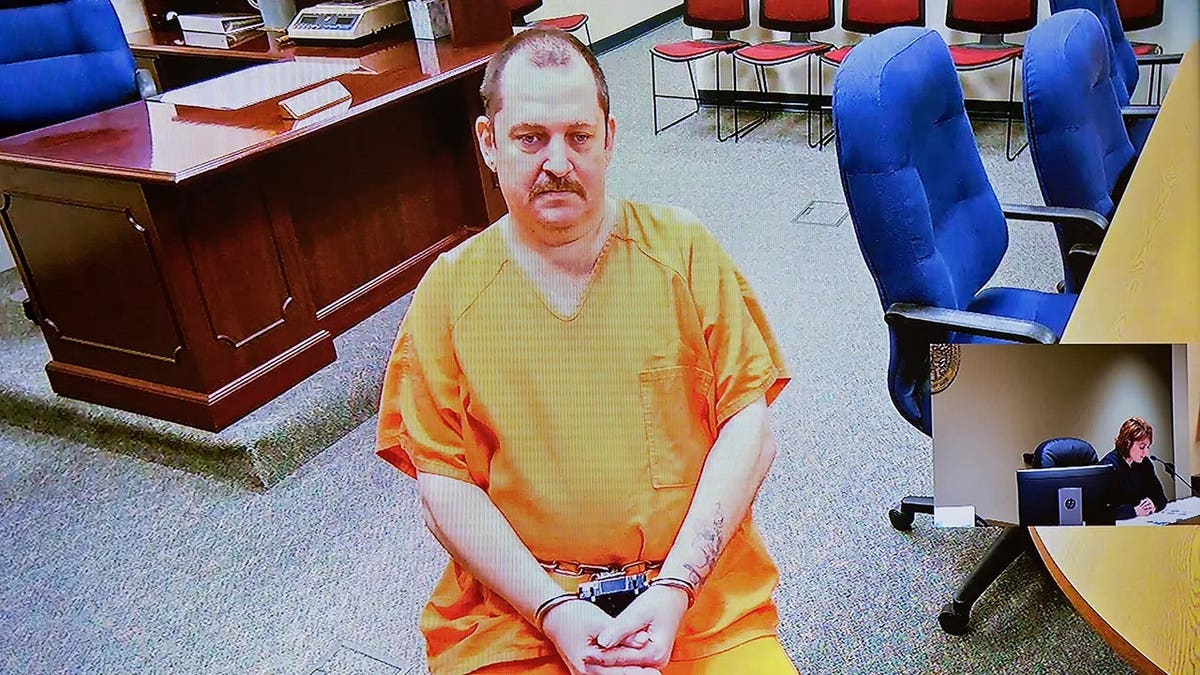 Aubrey Trail in an orange jumpsuit and handcuffs in court.