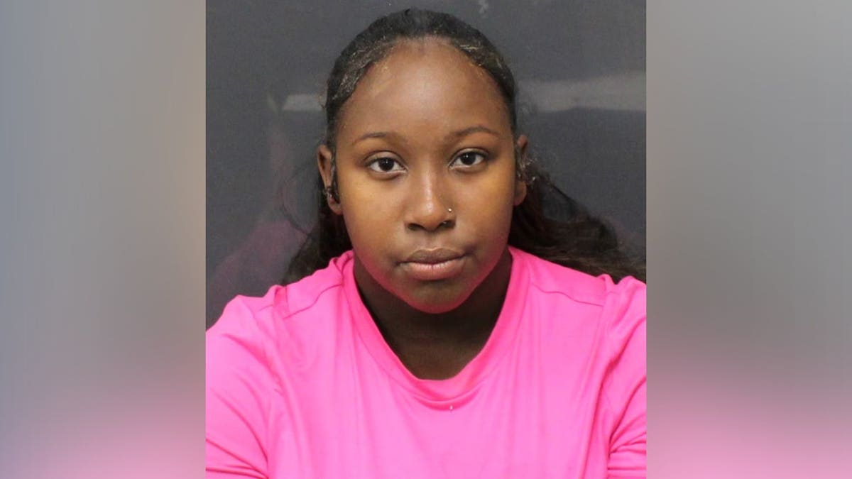 Mugshot of Mia Dawson, 20, wearing a bright pink shirt against a dark background.