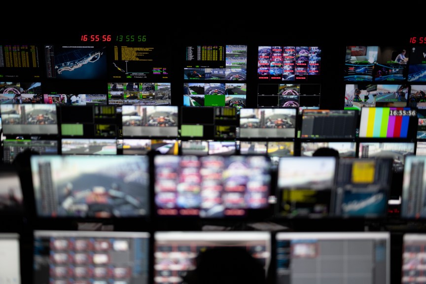 Rows of computer screens and monitors with track imagery and data