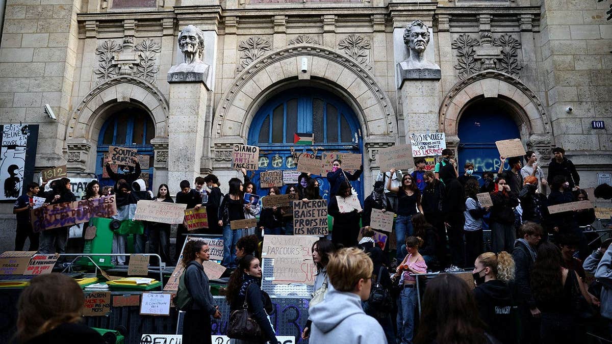 French high school students gather outside the Lycee Voltaire high school as part of nationwide protests