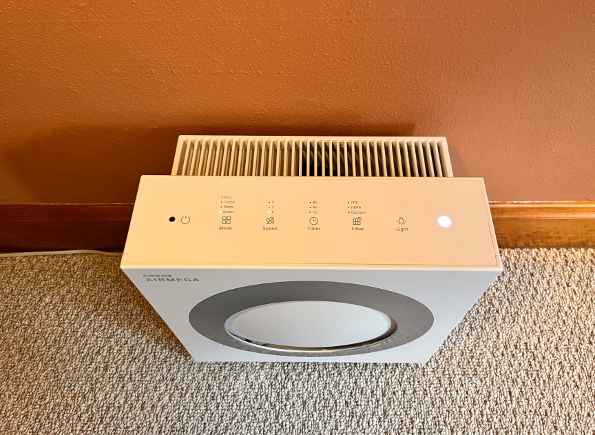 A white square Coway air purifier sitting on a floor