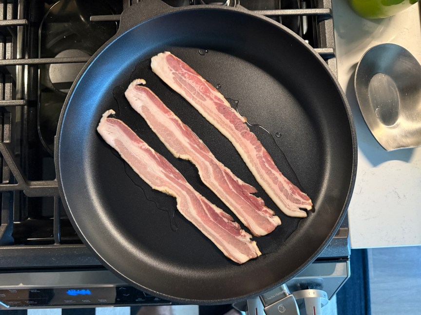 raw bacon placed flat in pan