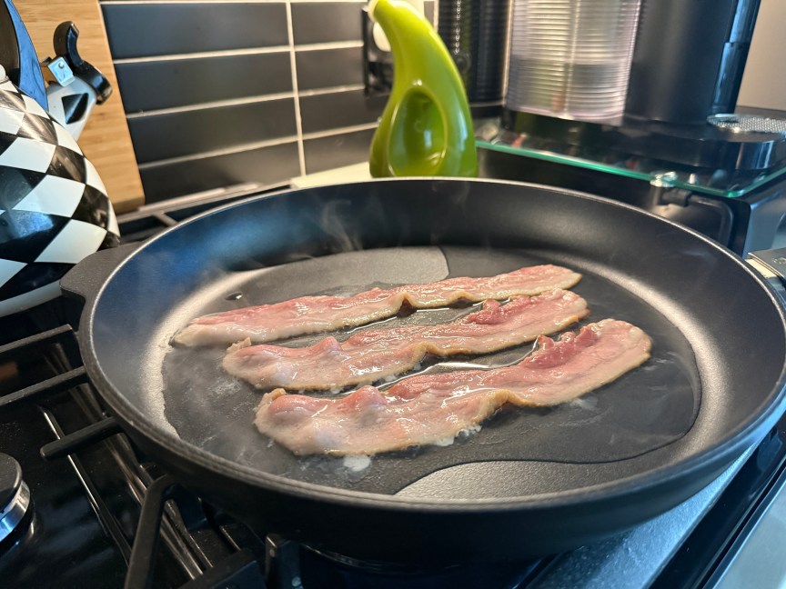 bacon sizzling in pan with water